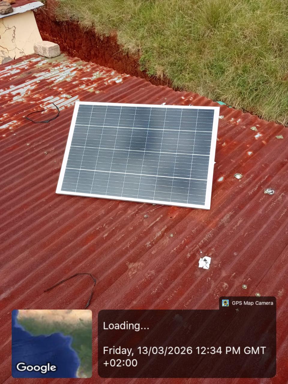 Solar panel laid out on a red roof surface during installation work.
